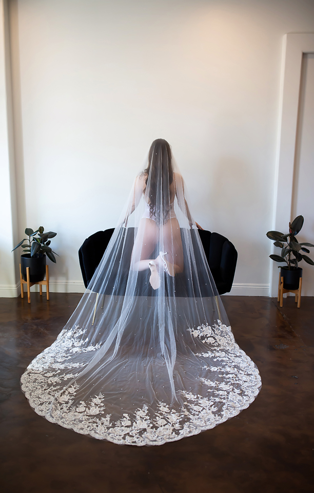 Bride with very long veil wearing white lingerie doing a Bridal Boudoir session by Kellie Foster
