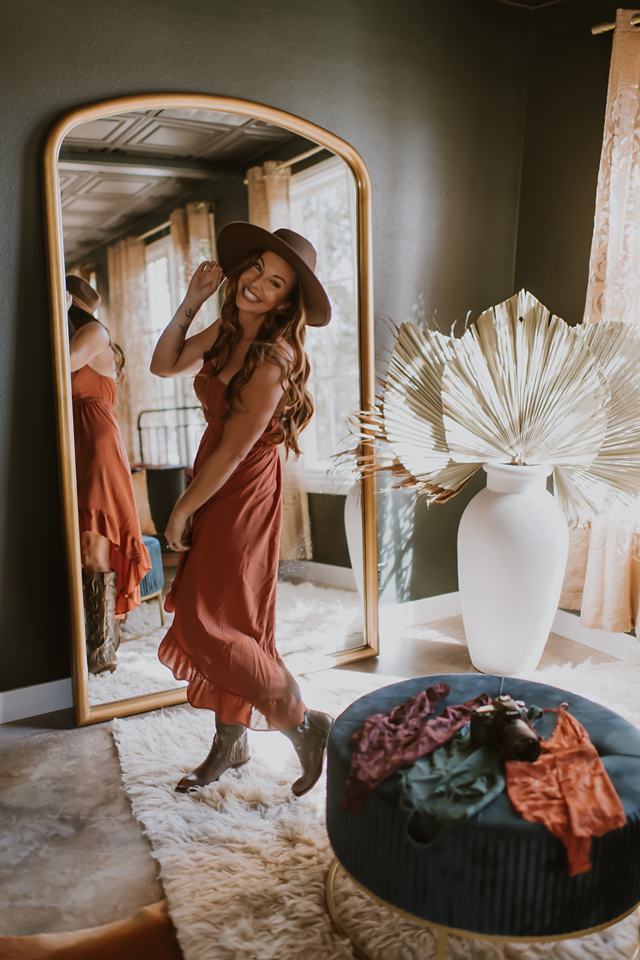 Kellie Foster Photography in a hat, smiling and dancing in cowboy boots